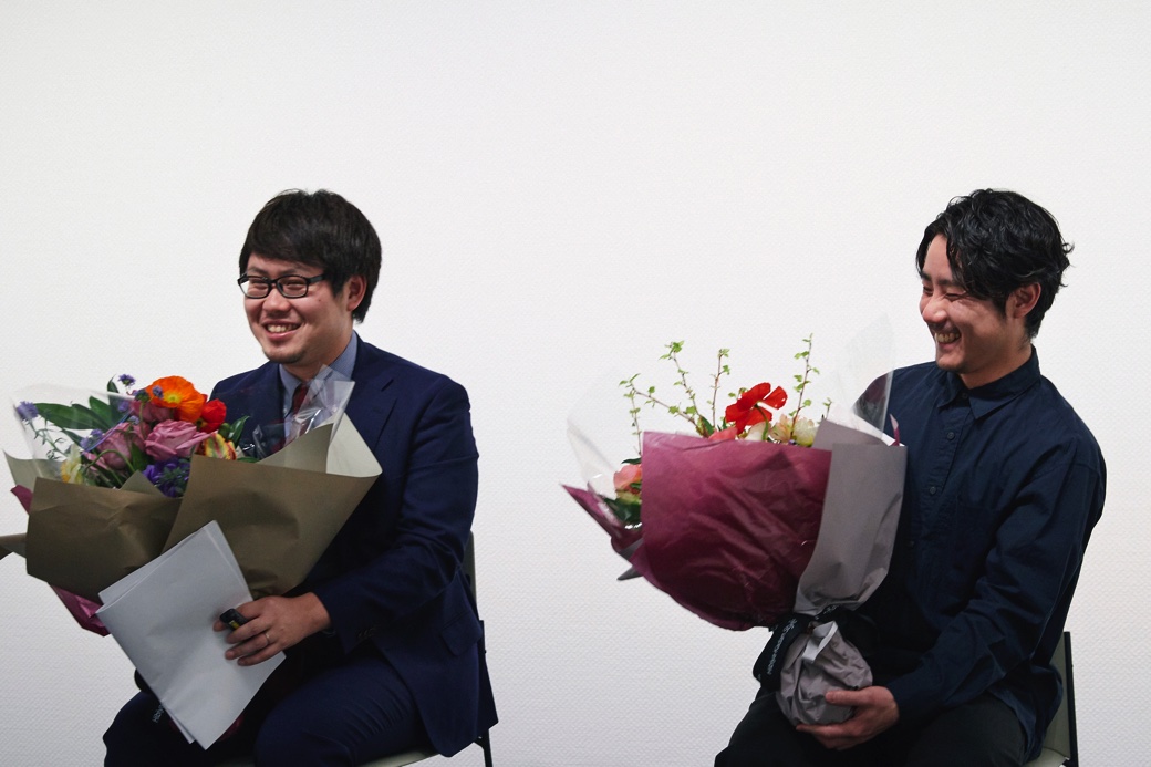 花束を受け取った丸善雄松堂株式会社の林泰斗さん（左）と、株式会社アマナの濱谷俊輔